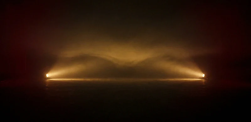 Two lamps in a hazy dark room pulse together, and the light between them builds brighter than either alone before settling